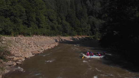 Aerial View of People Floating in Boat on Mountain River