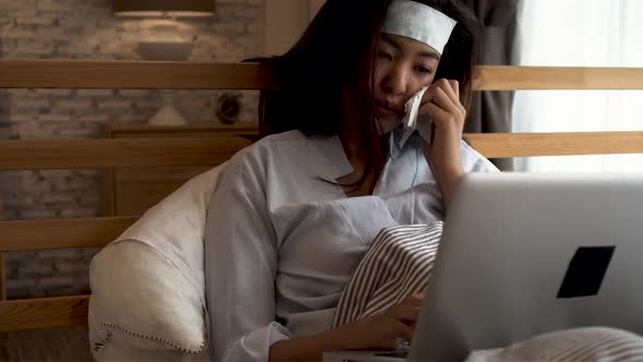 20s Young Asian Woman Having Cold in Bedroom at Home Using Gel Sheet to Reduce Temperature