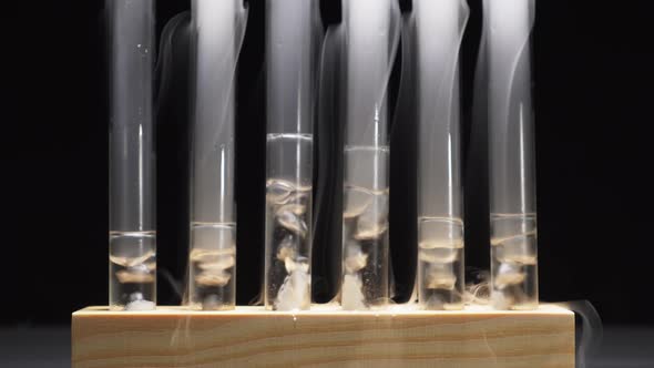 Smoky Glass Test Tubes with Dry Ice on a Black Background alt