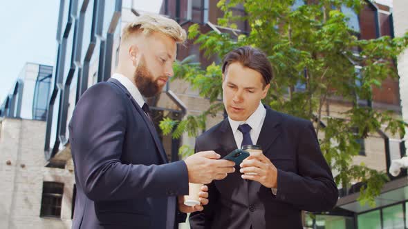 Confident businessman and his colleague in front of modern office building.