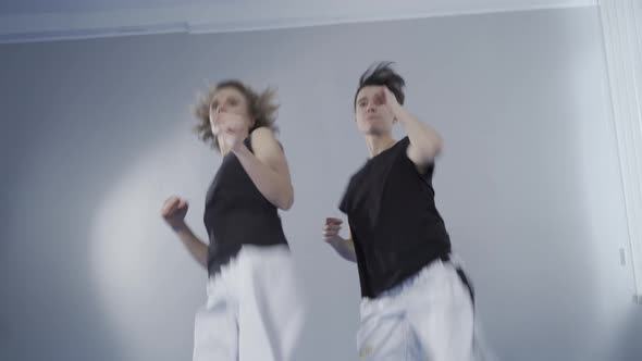 Two Female Athletes at Taekwondo Training Do Quick Kicks