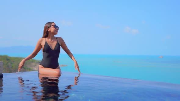 Young asian woman enjoy around outdoor swimming pool for leisure