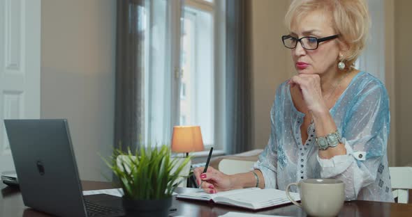 Worried Old Senior Woman Reading Paper Bill Pay Online at Home Managing Bank Finances Calculating