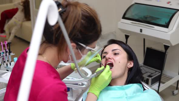 Dentist Cleans Woman's Teeth with Professional Toothpaste and Automatic Brush