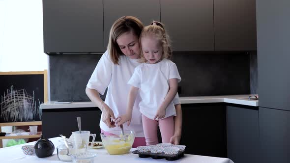 Happy Mother and Daughter Preparing Cupcakes in Kitchen