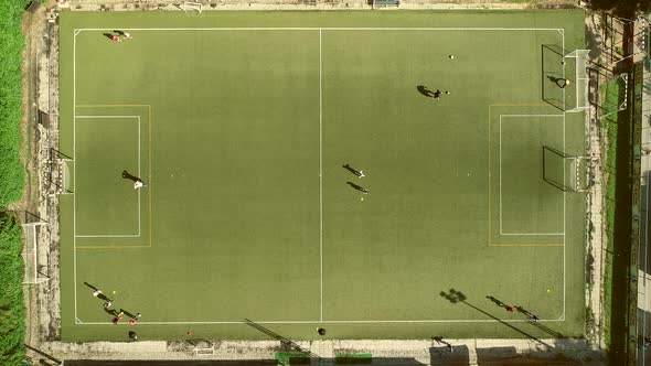 Aerial view of people training football in a beautiful football camp.