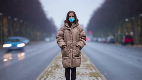 Time lapse of young woman wearing face mask and standing on city street