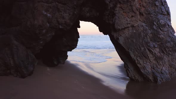 Aerial Drone View of Lisbon Beach, Flying Through Arch Rock Formation Small Gap, on the Portugal Coa