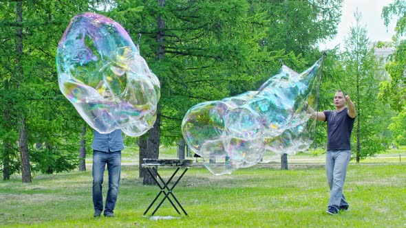 Performers Creating Huge Bubbles in Park