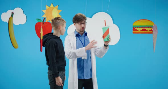 Doctor Explaining To Boy About Healthy and Unhealthy Food
