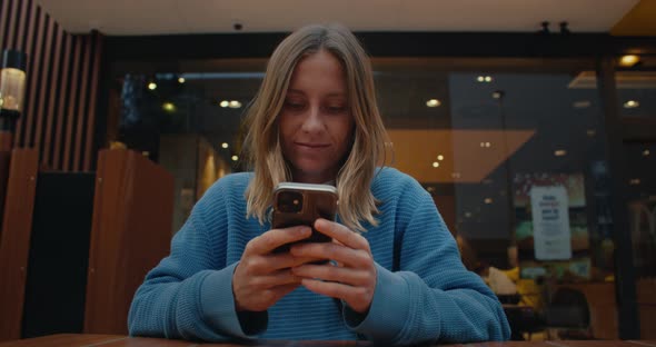 Young Beautiful Woman Using Smartphone in Cafe