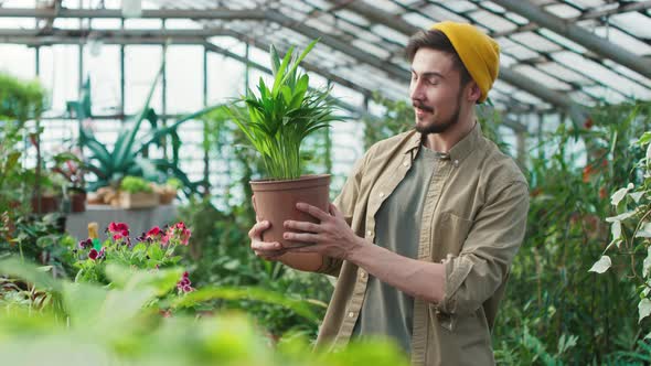 Portrait of Man with Houseplant in Greenhouse