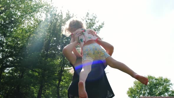 The Little Daughter Runs to Her Mother and Then They Spin Around Together in the Backyard