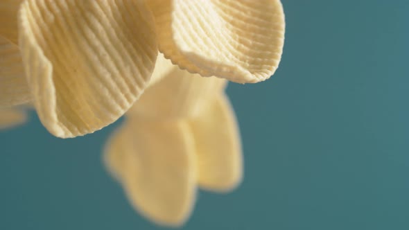 Camera follows potato chips flying in the air. Slow Motion.