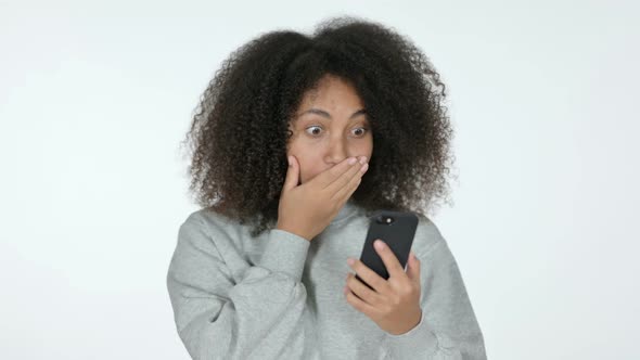 African Woman Celebrating on Smartphone, White Background 