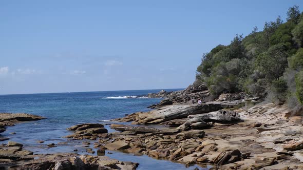 Wide shot of a rocky coast in the royal national park in Australia near Sydney with ocean and bush f