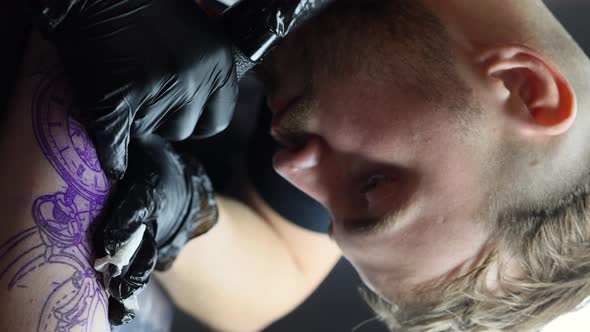 Tattoo Master is Tattooing a Man's Hand