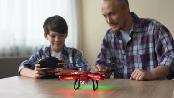 Cheerful Boy Operating Drone With Remote Control, Dad Catching Quadcopter, Fun