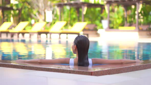 Young asian woman enjoy around outdoor swimming pool for leisure