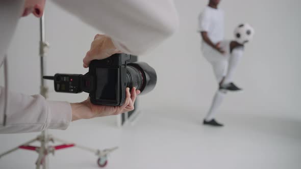 Photographer Takes Professional Photos of a Black Football Player in the Studio on a White