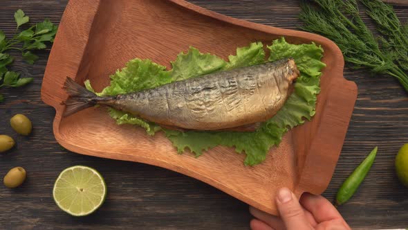 Male Hands are Placing a Wooden Plate with Delicious Juicy Grilled Red Char Fish