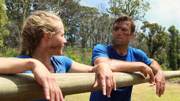 Fit man and woman interacting with each other during obstacle course