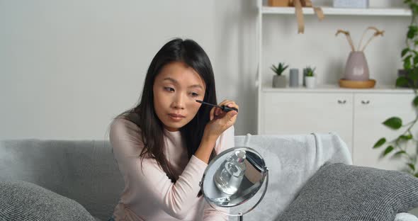 Confident Calm Focused Asian Young Woman Holding Mascara Apply on Eyeleashes Prepare for Date