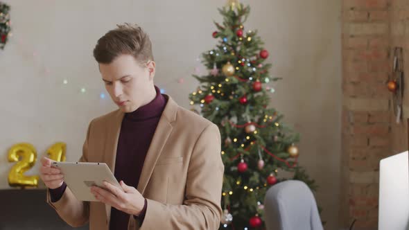 Portrait of Busy Businessman in Office Decorated for Christmas