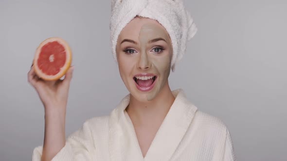 Woman in Bath Robe, Towel on Head and Clay Mask Hiding Her Eye with Fresh Fruit