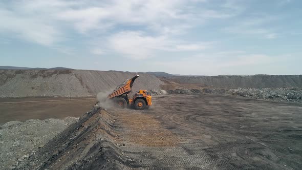 Multiton Dump Truck Folds Its Body and Leaves After Unloading Waste Rock