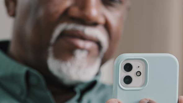 Unfocused Unrecognizable Mature Elderly African 60s Biracial Man with Gray Beard Using Phone Looking