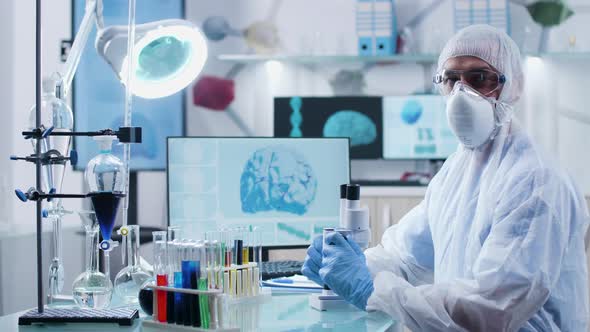 Concentrated Chemist Wearing Protective Mask, Clothes and Glasses Looks at the Camera