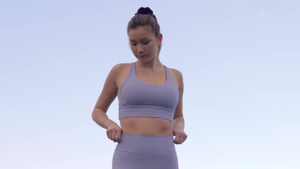 Young woman adjusting sports bra and matching leggings, Slow Motion