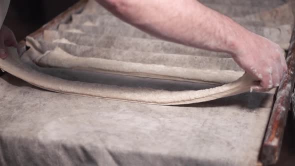 Baker Preparing Rows of Uncooked Dough Loaf in Bakery Production To Next Phase of Baking