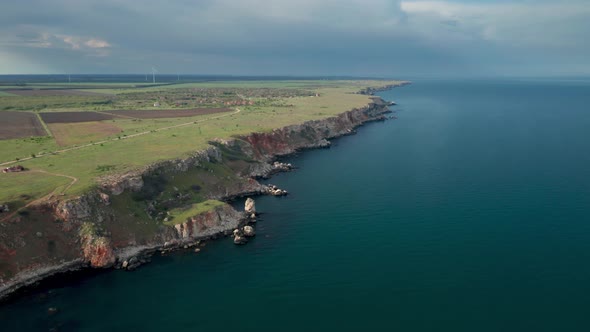 Picturesque rocky coastline with green fields