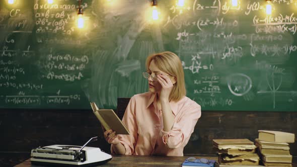 Beauty Student Girl with Glasses Read Books in the Collage or University Library