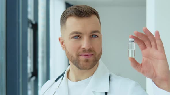 A Doctor Holds an Ampoule with a Vaccine in His Hand