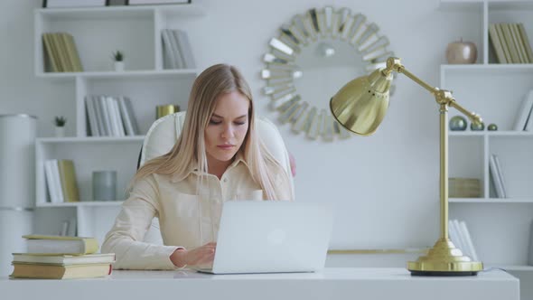 Focused woman entrepreneur typing on laptop doing research