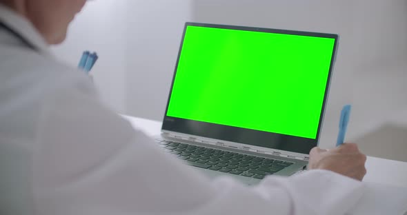 Woman Doctor Is Consulting Online, Looking at Green Display of Laptop for Chroma Key Technology