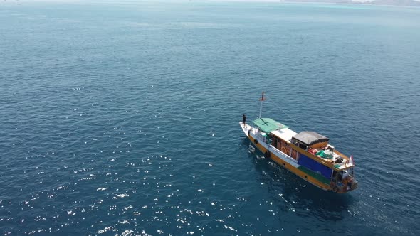 Aerial drone shot of a traditional South Asian boat sailing through the sea on a sunny day. Komodo I