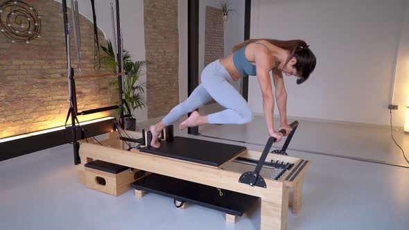 Woman stretching legs on pilates reformer