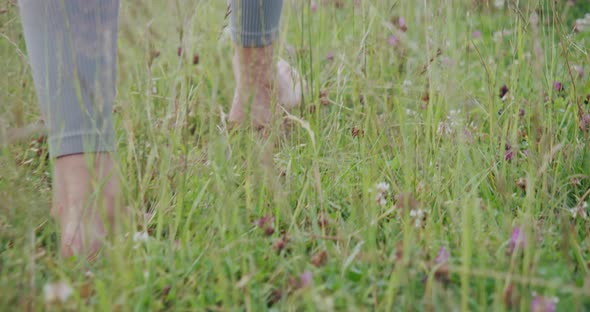 Close Up of Young Woman Walking on Fresh Grass with Barefoot
