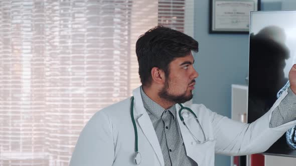 Close-up of Mixed Race Doctor in Lab Coat Talking About Athlete's Brain MRI