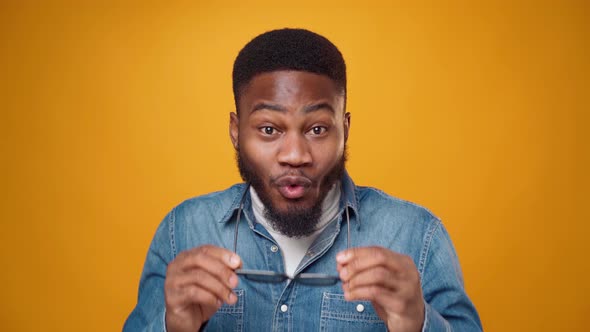 Young African American Man Thinking Against Blue Background
