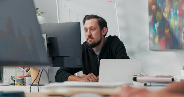 Satisfied Office Worker Sits in Front of the Computer Monitor Happy to Receive a Promotion Email