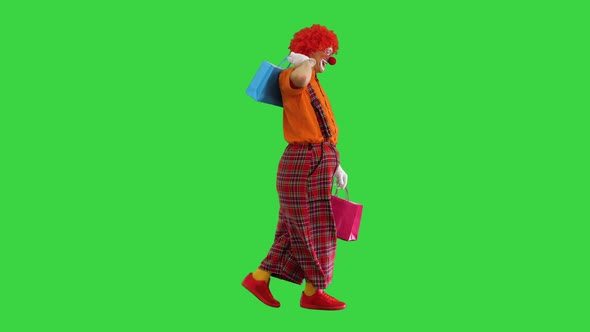 Funny Clown on a Walk with Shopping Bags on a Green Screen Chroma Key
