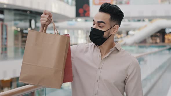 Young Guy in Medical Mask Holding Shopping Bags Showing Thumb Up Satisfied Services Arab Man