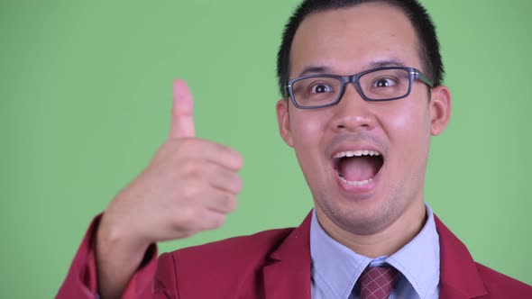 Face of Happy Asian Businessman with Eyeglasses Giving Thumbs Up