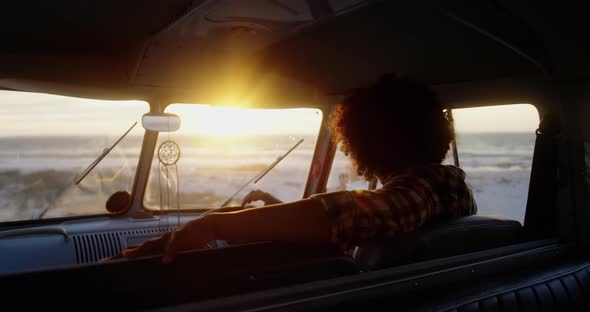 Man relaxing in camper van at beach 4k