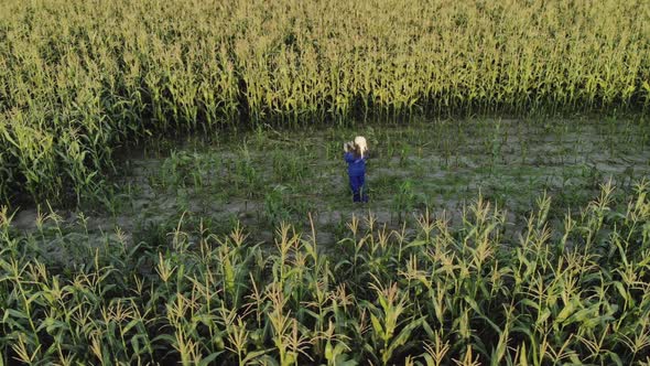 Woman Agronomist in Overalls with an Electronic Tablet in His Hands. An Agricultural Worker Inspects